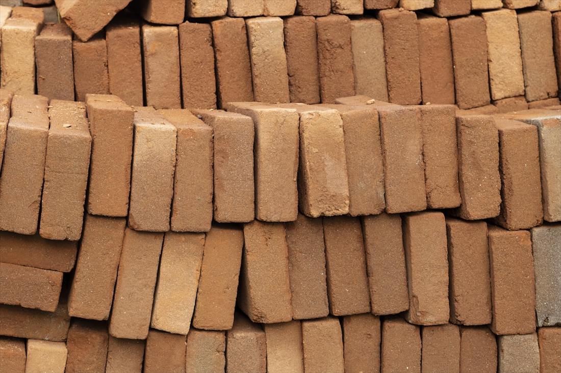 Clay bricks stacked in banded packs at a brick yard.