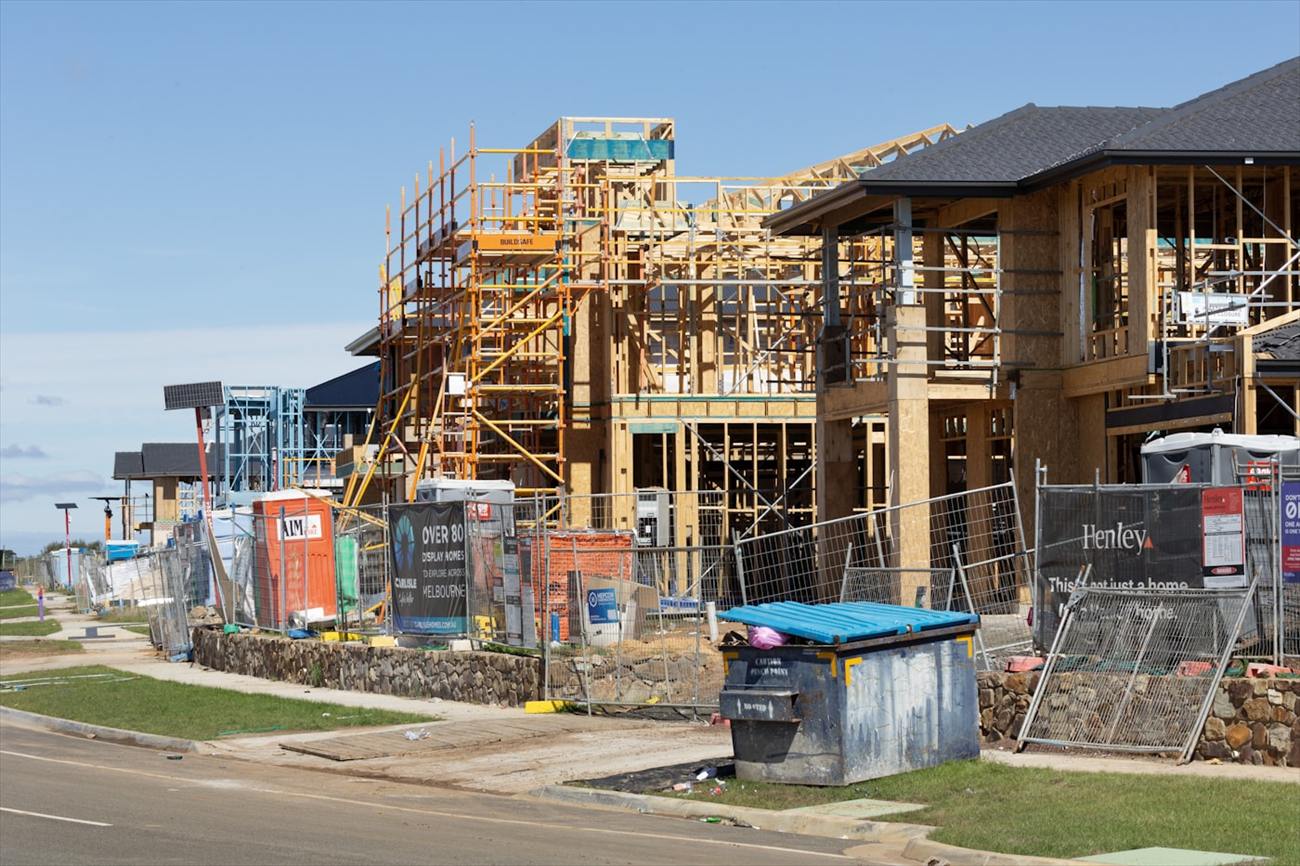A row of new houses under construction with timber frames up.
